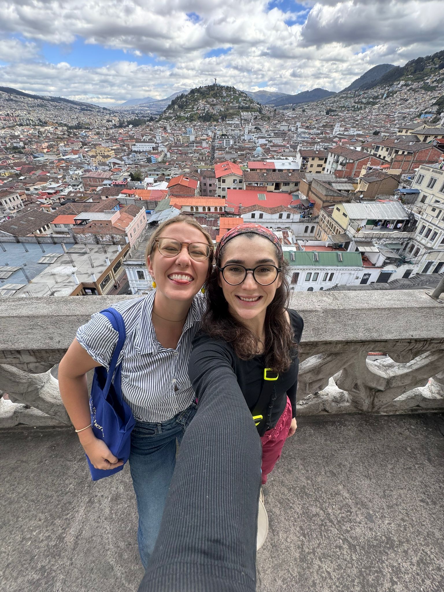 Two female students pose for a photo overlooking Quito, Ecuador.