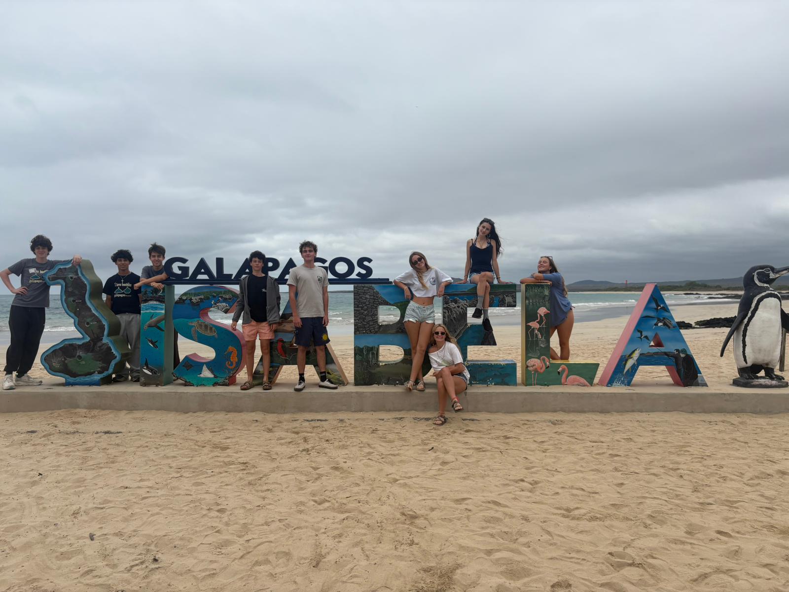 Students posing with the Isabela sign on Isabela Island in the Gal&aacute;pagos, Ecuador