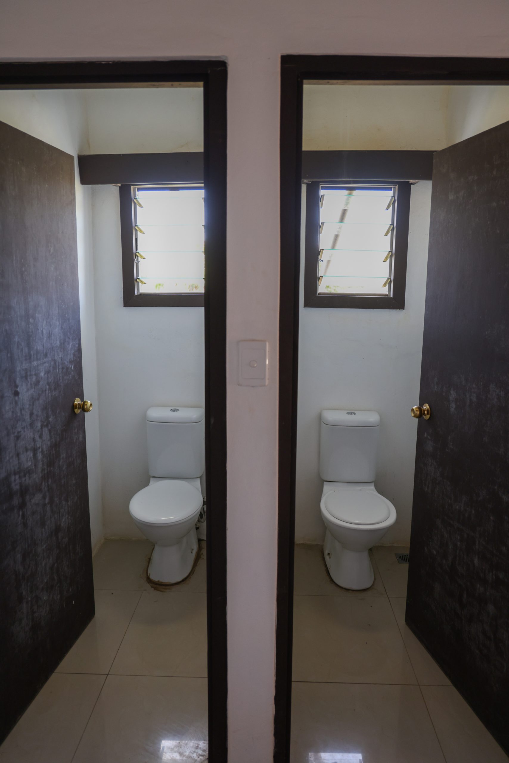 Clean bathroom with toilet and basin at a Rustic Pathways base house in Fiji.