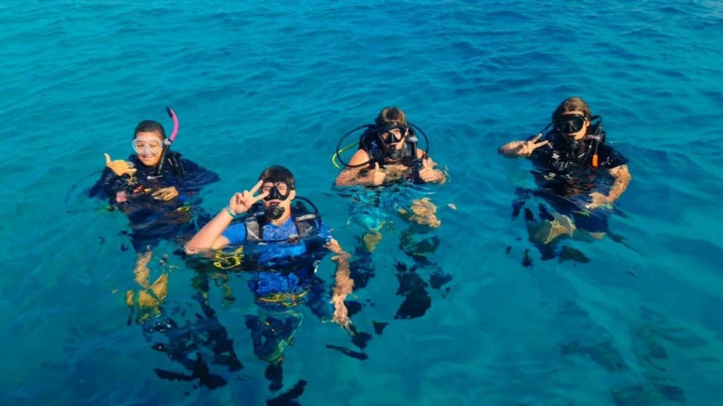 Students preparing to snorkel in the Fiji coral reefs posing for a photo.