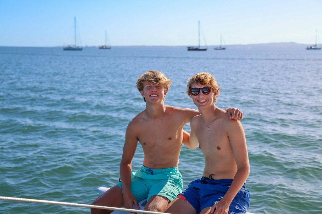 Two students smiling on a boat during a Rustic Pathways volunteer abroad trip, showcasing friendship and adventure while choosing the right volunteer program abroad.