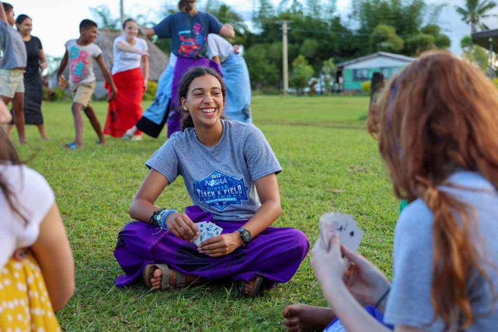 Teen tour participants enjoying free time playing games in a village in Fiji.