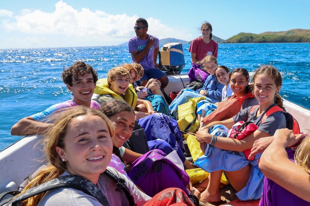 A group of students on a boat trip during a summer teen tour.