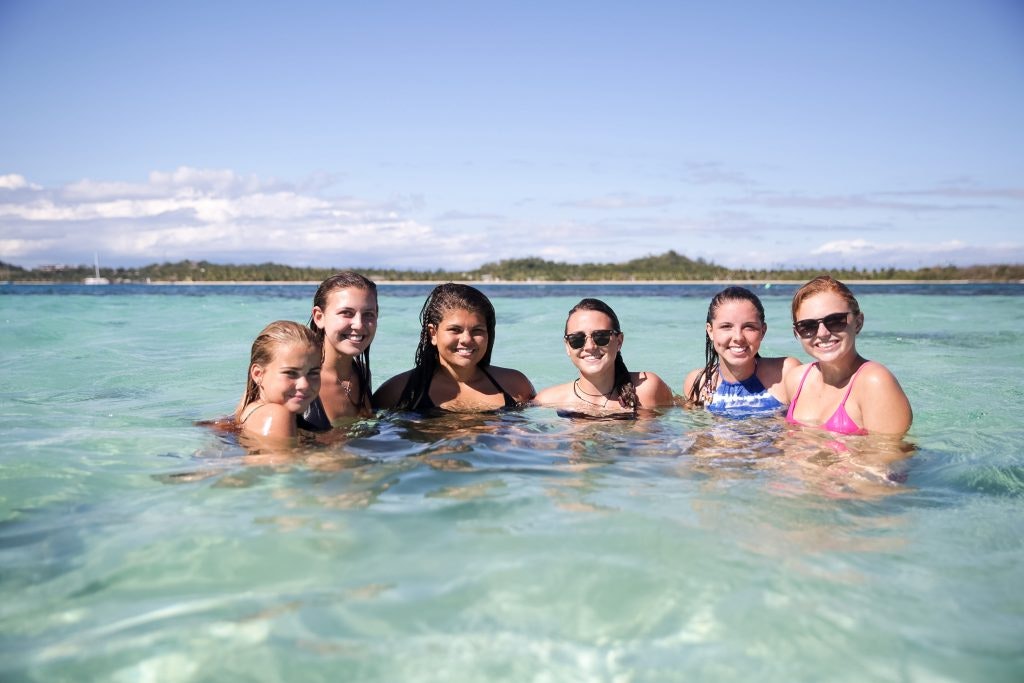 Rustic Pathways students swimming in the ocean during a spring break teen tour