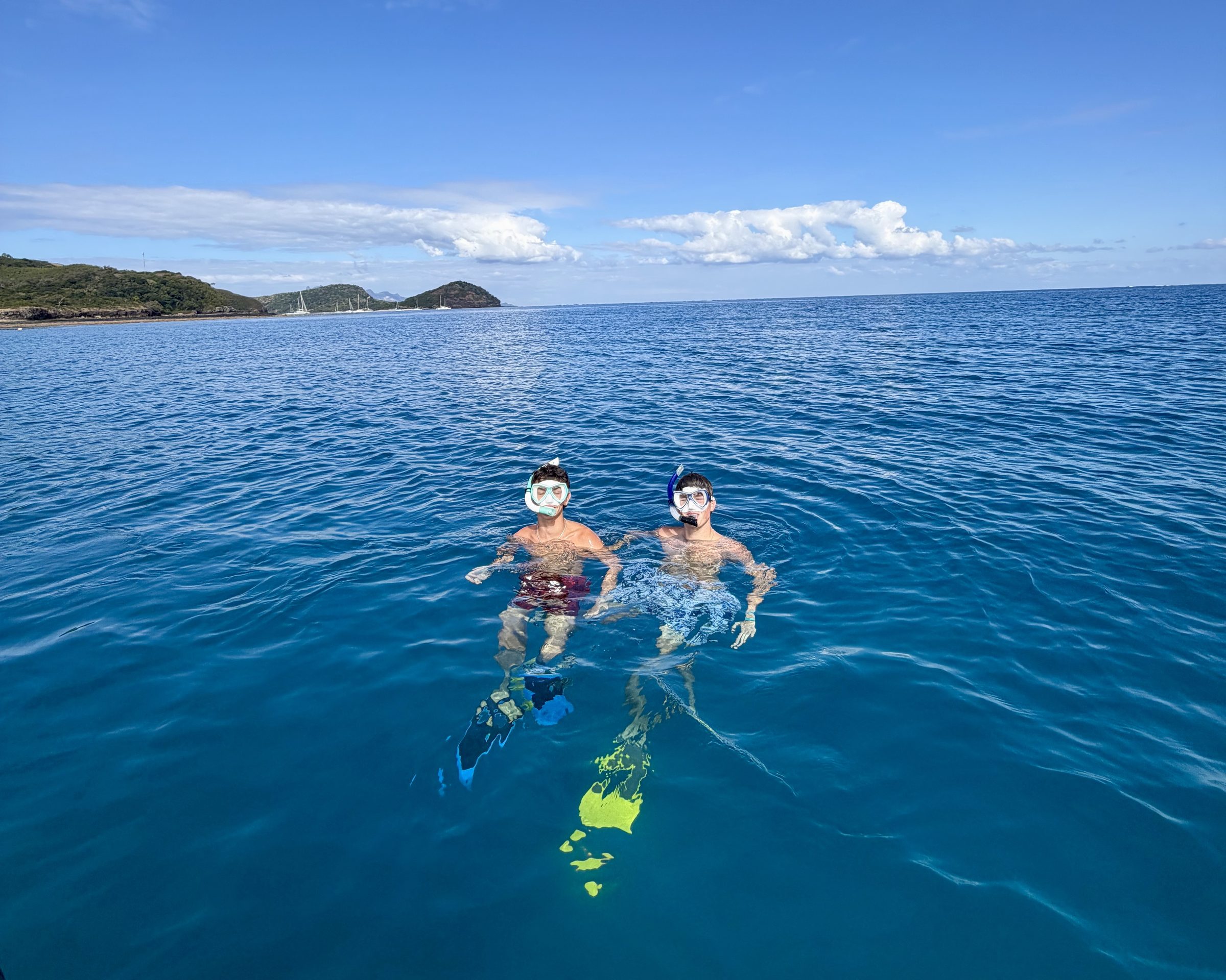 Two students snorkel in deep blue water off the Fijian coast