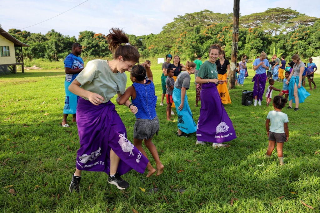 A group of teens and children dance and play together at summer camps for teens.