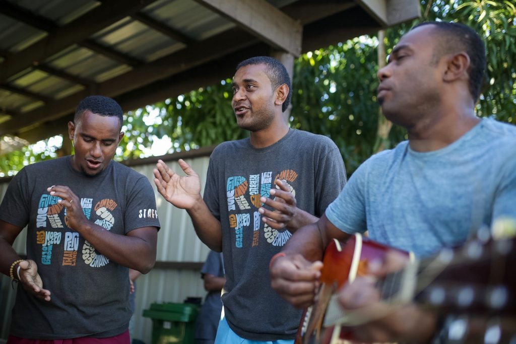 Rustic Pathway's program leaders singing a song with a guitar and three singer.