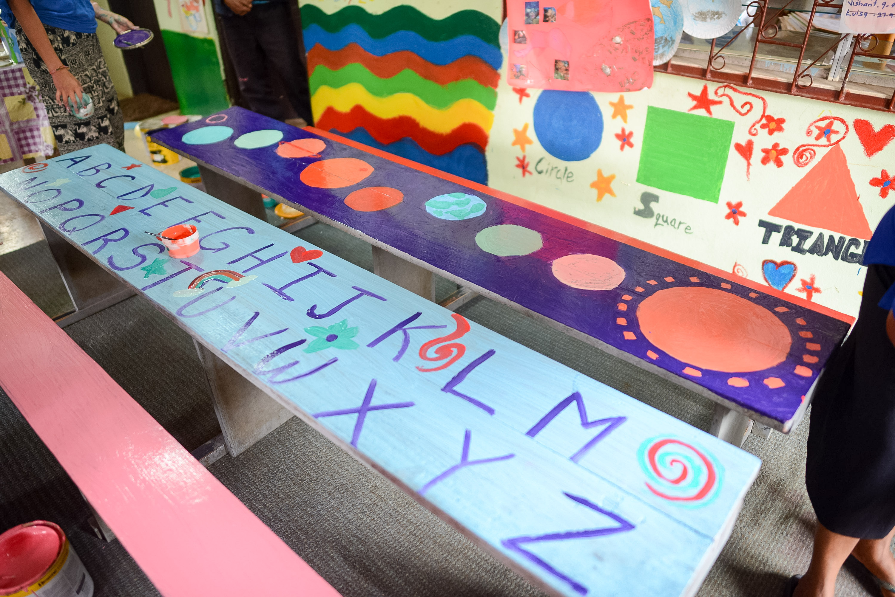 A school trip work project produced wooden benches painted with alphabet letters and colorful shapes