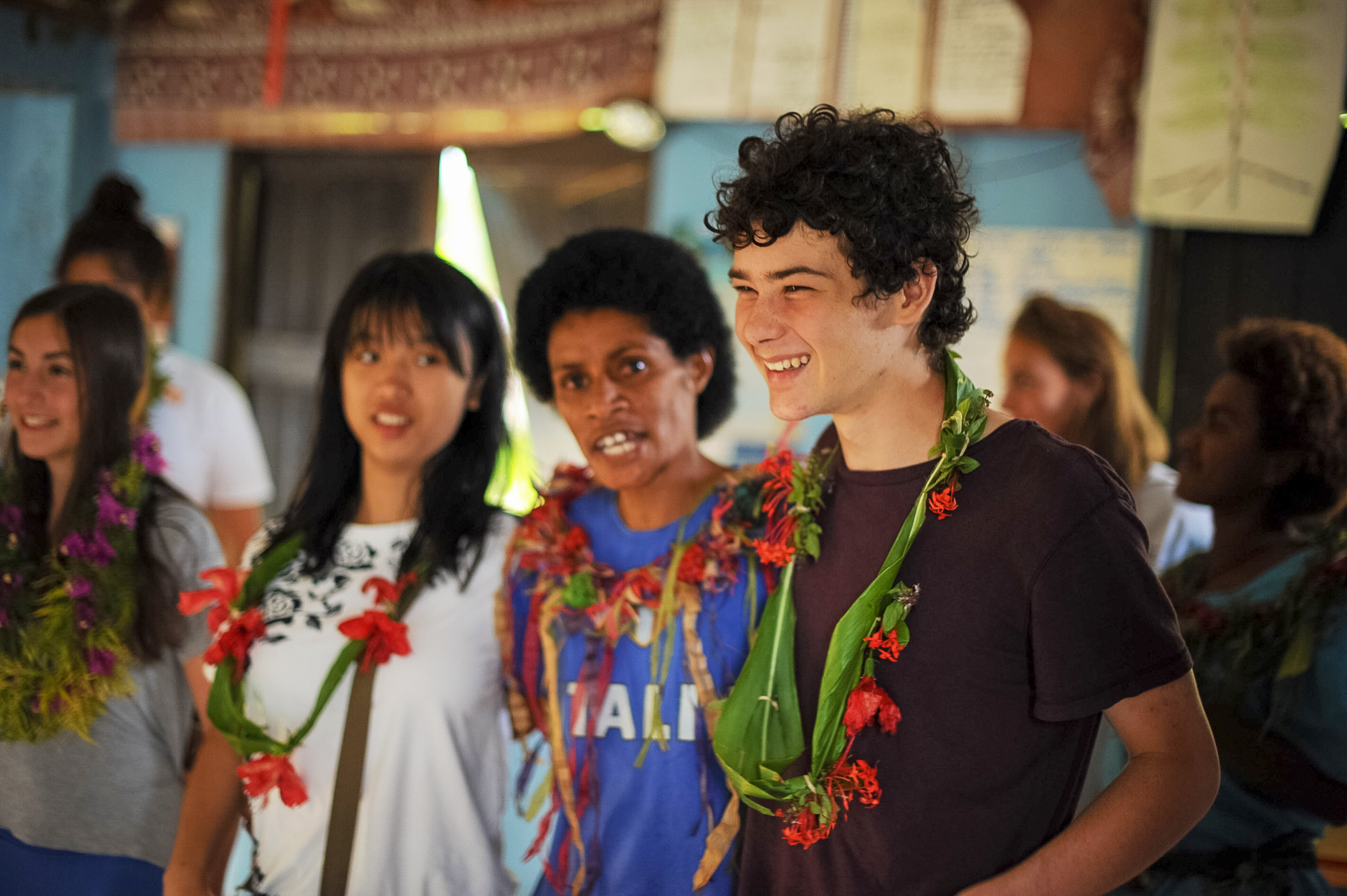 Students wear floral leis during a welcome ceremony in Fiji