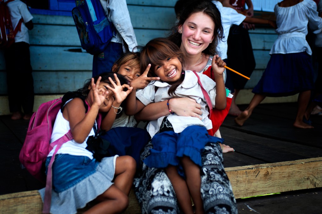 A student poses with local children flashing peace signs in a Cambodian village