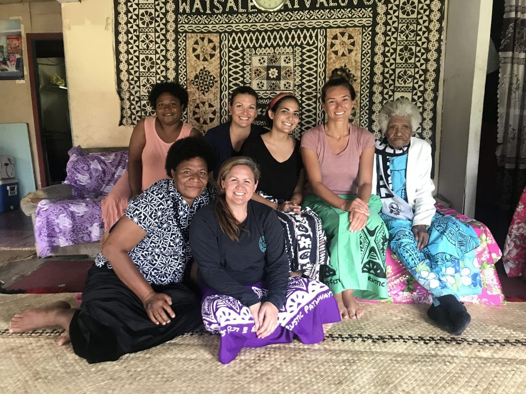 Group photo with Fijian villagers inside a traditional home