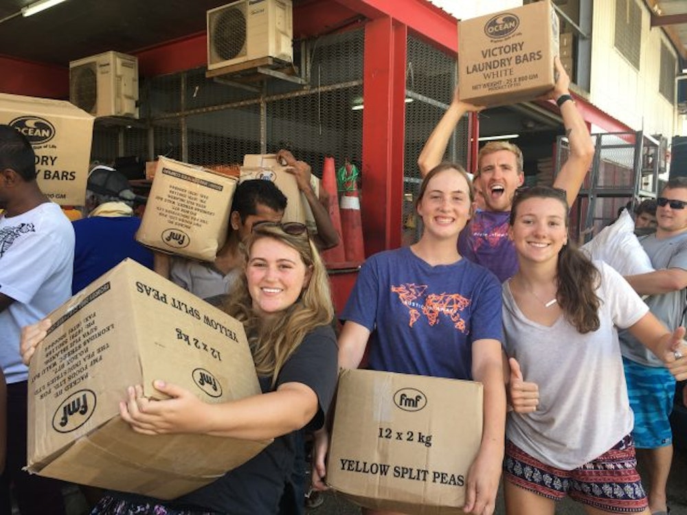 people holding boxes of supplies helping after the cyclone