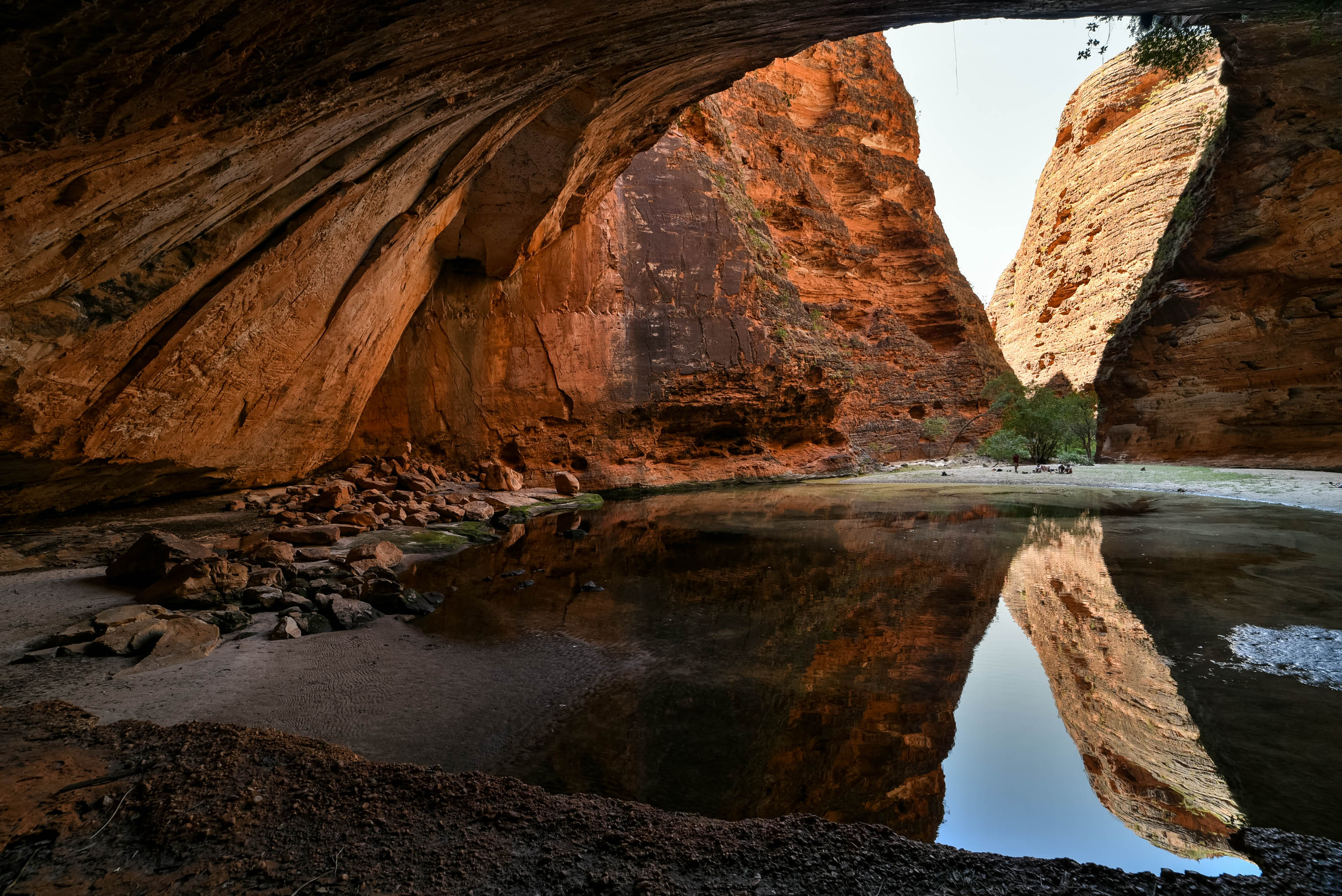 A still pool mirrors the striped sandstone walls of a Kimberley gorge