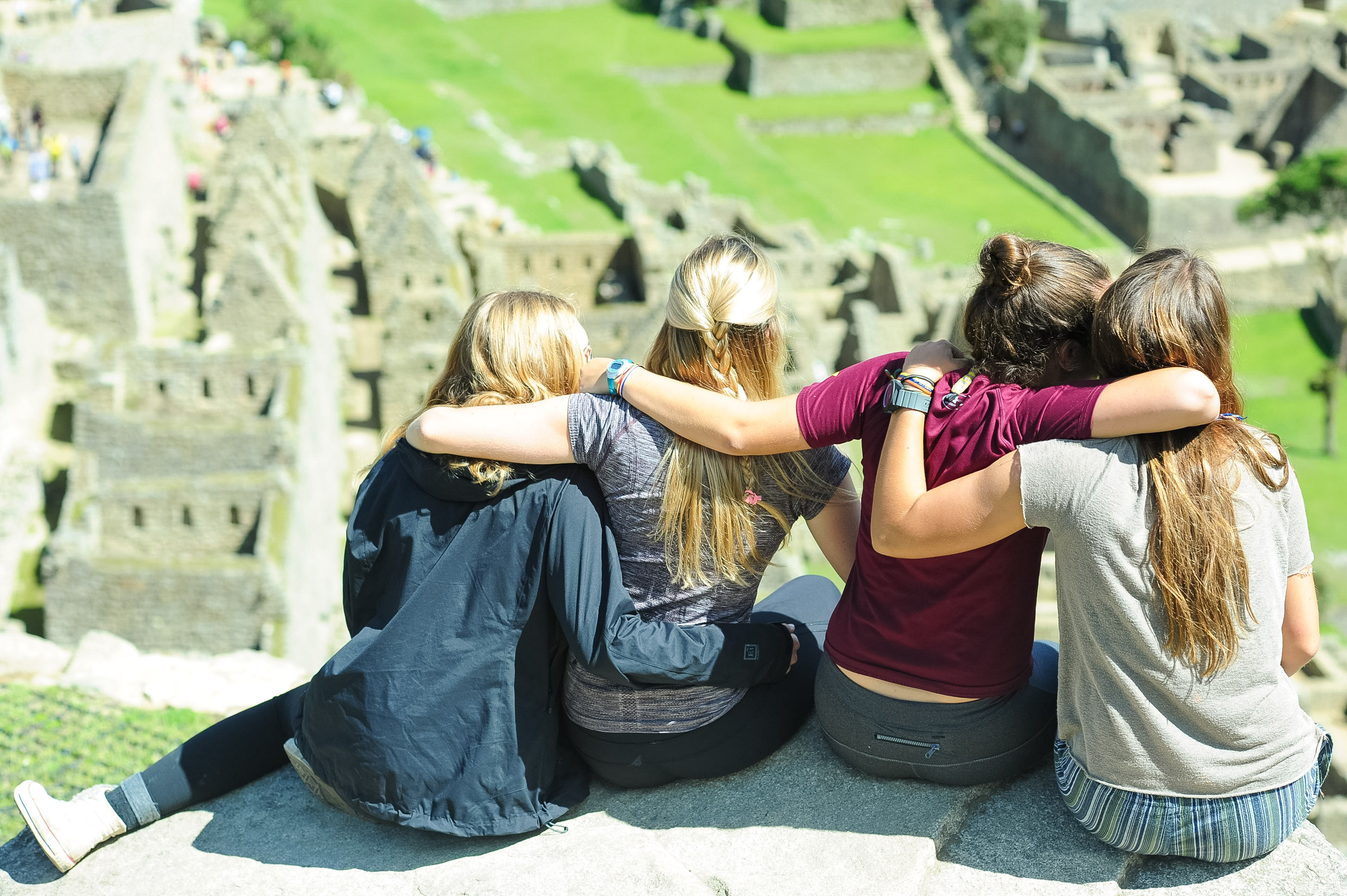 students sitting arm in arm overlooking Machu Picchu in Peru