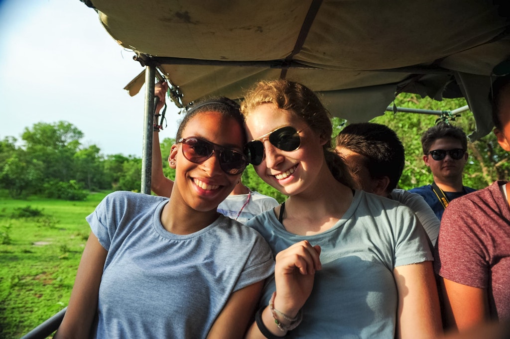 Students smiling during a safari-style ride while volunteering abroad in Africa, combining adventure with meaningful community service.
