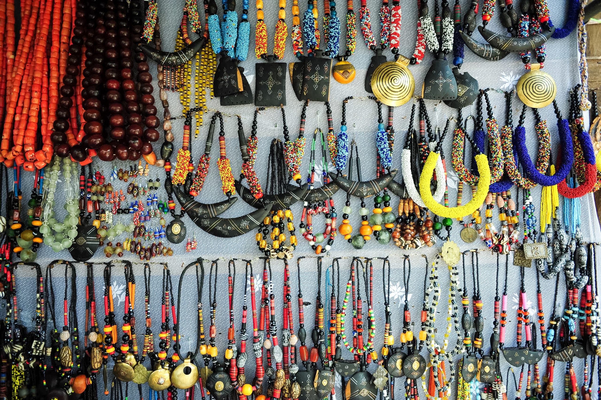 Colorful beaded necklaces and pendants hang for sale at a market stall
