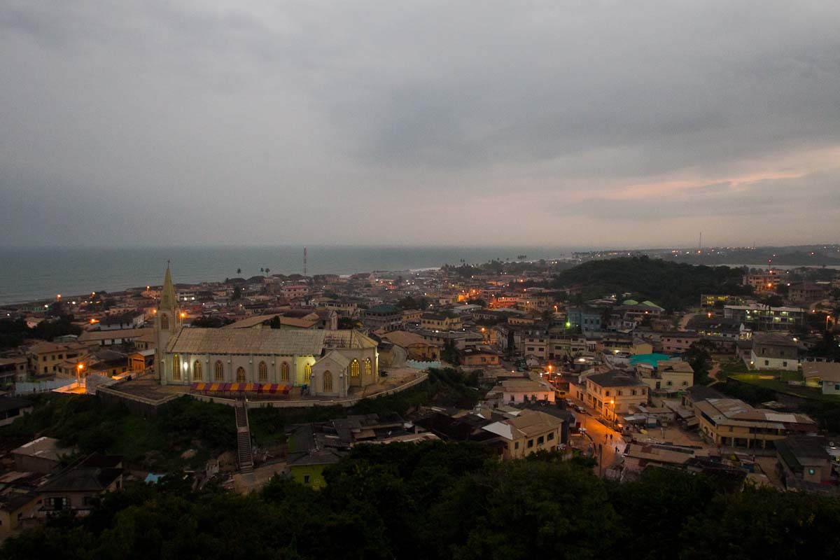 A coastal town with a white church spire seen from above at dusk