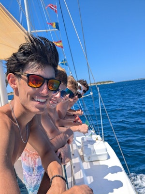A group of students smile on a boat during a teen tour in Portugal and Greece