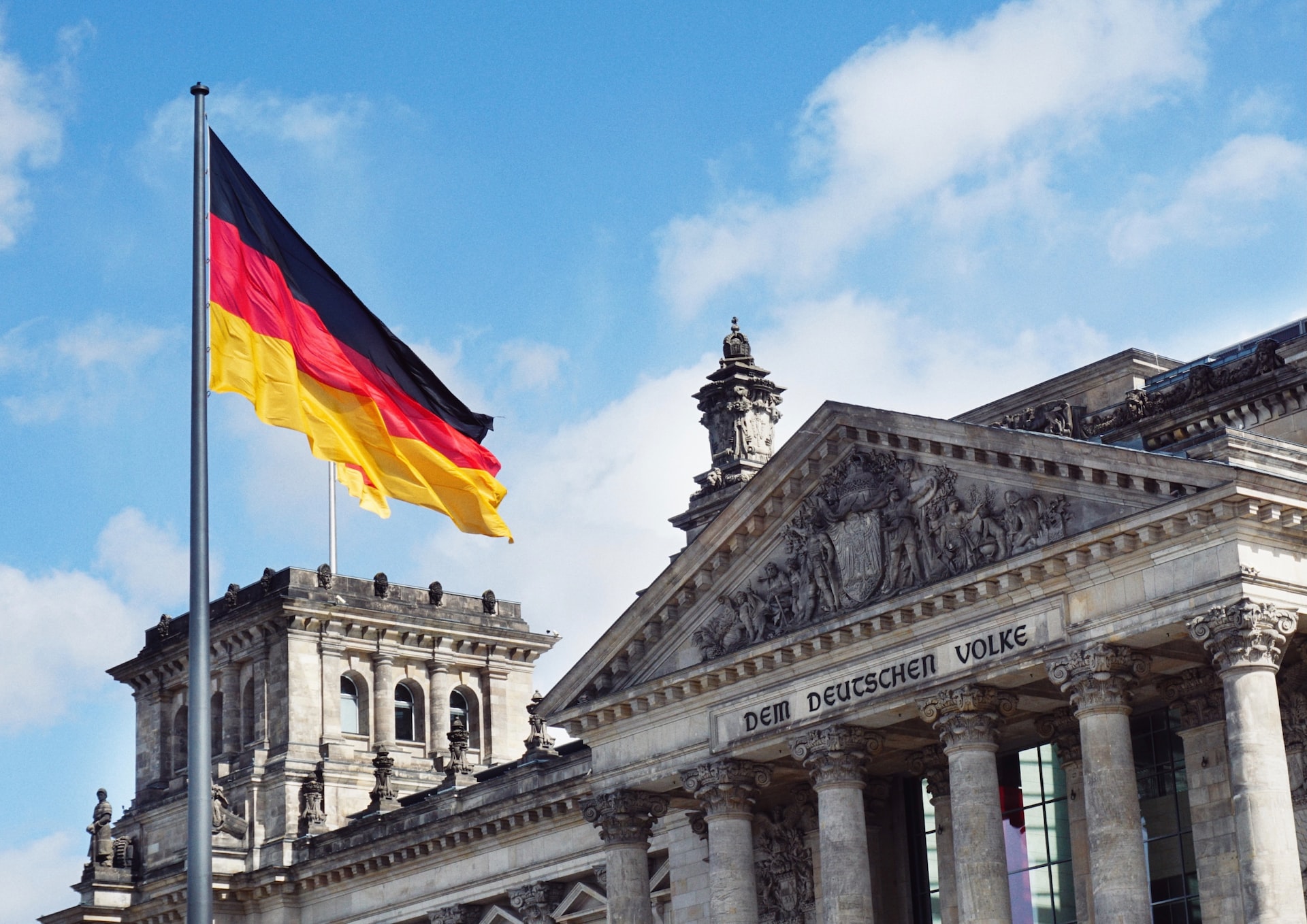 The German flag waving above a neoclassical building.