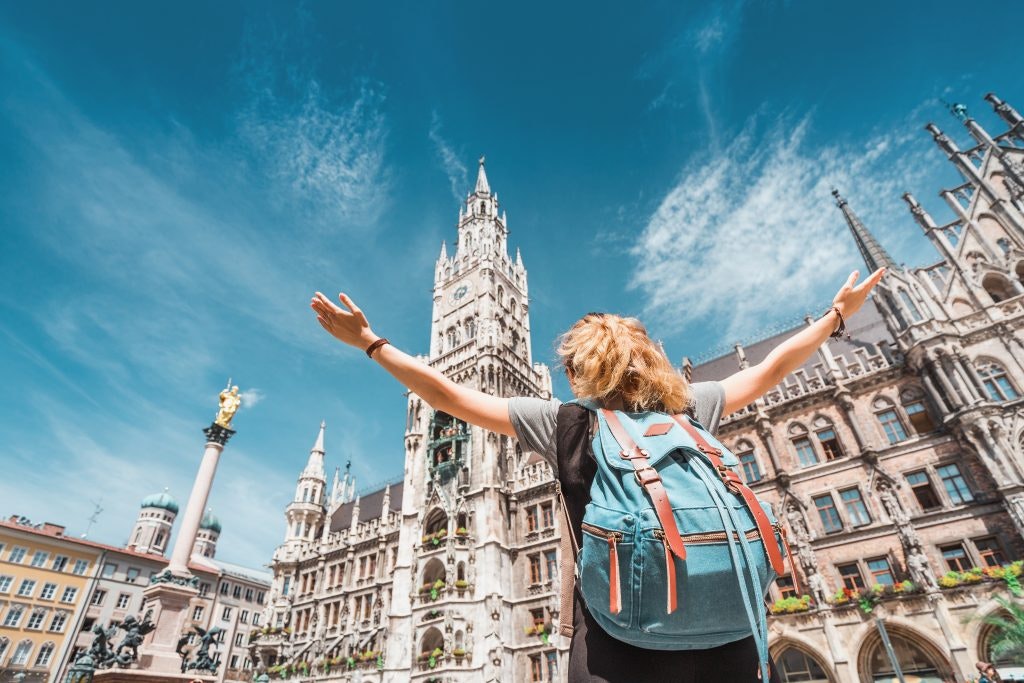 A girl tourist traveler enjoys a Grand view of the Gothic building of the Old town Hall in Munich.