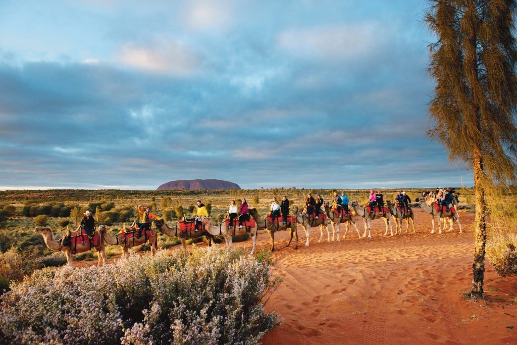 Rustic Pathways students take a camel ride near Uluru.