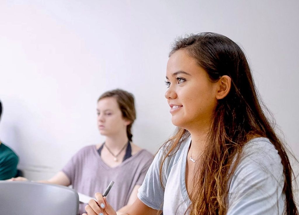 IB students collaborating in class, connected to the IB Learner Profile attributes like communicators, thinkers, and reflective learners