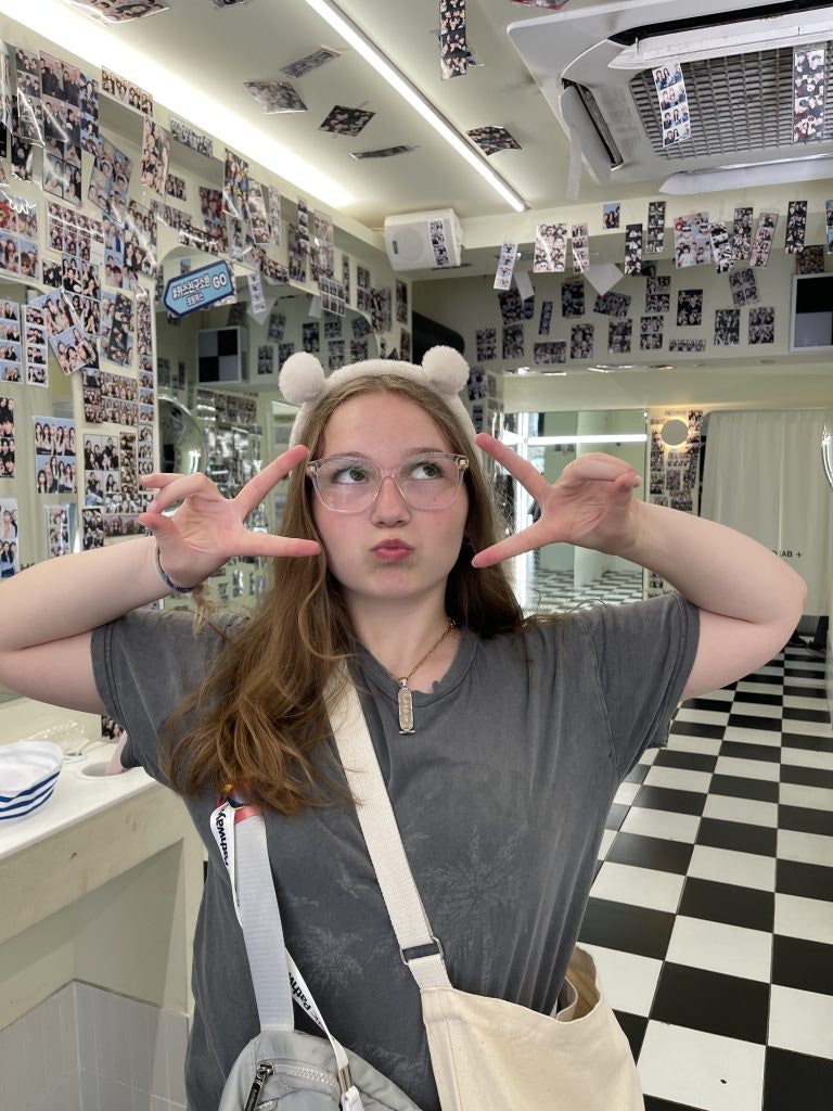 A female student poses inside an instant photo studio in Seoul during a South Korea teen tour.
