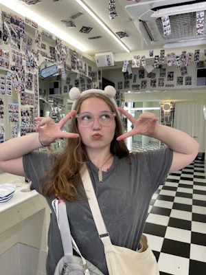 A female student poses cutely inside an instant photo studio in Seoul during a South Korea teen tour.