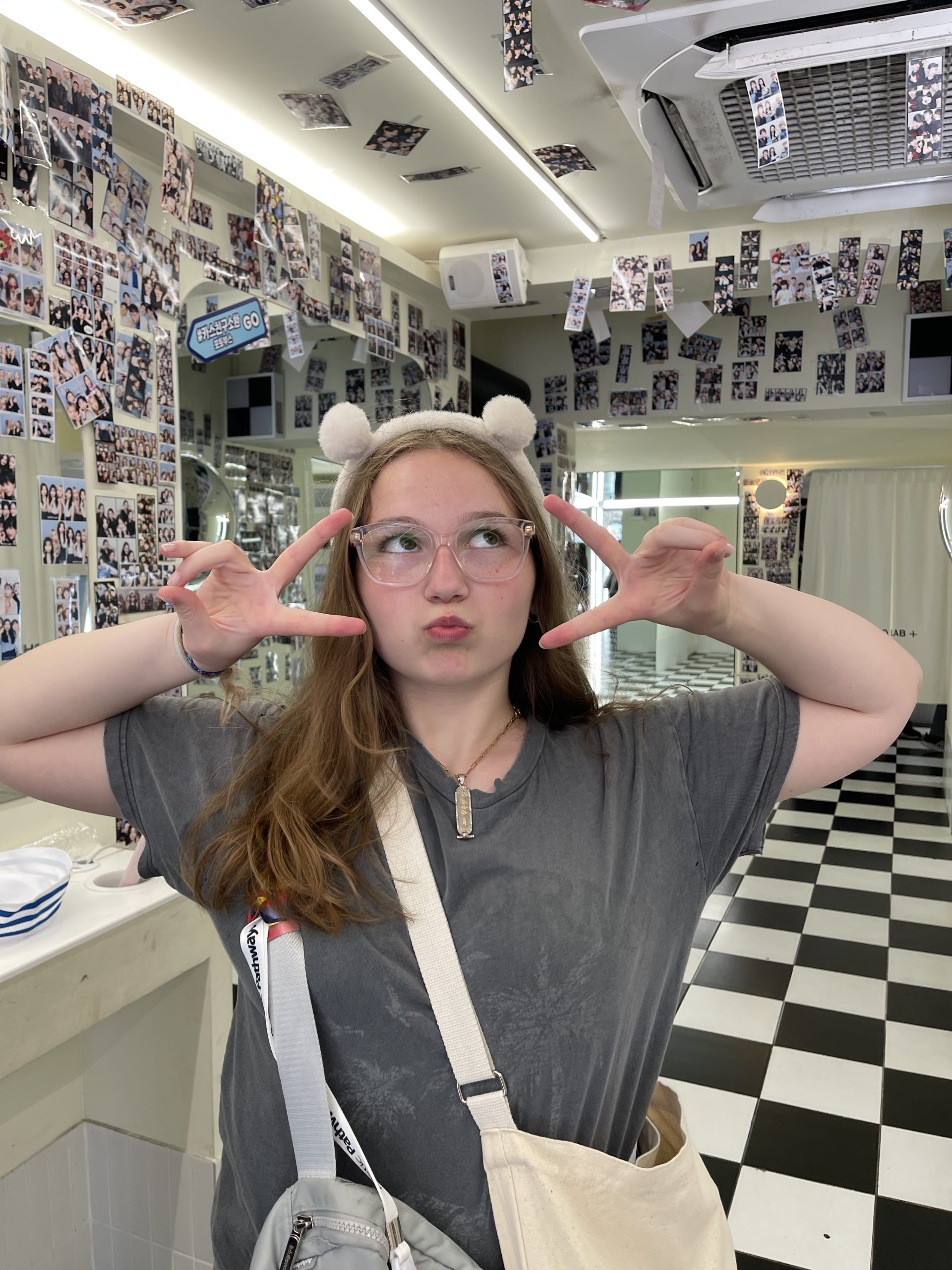 A female student poses cutely inside an instant photo studio.
