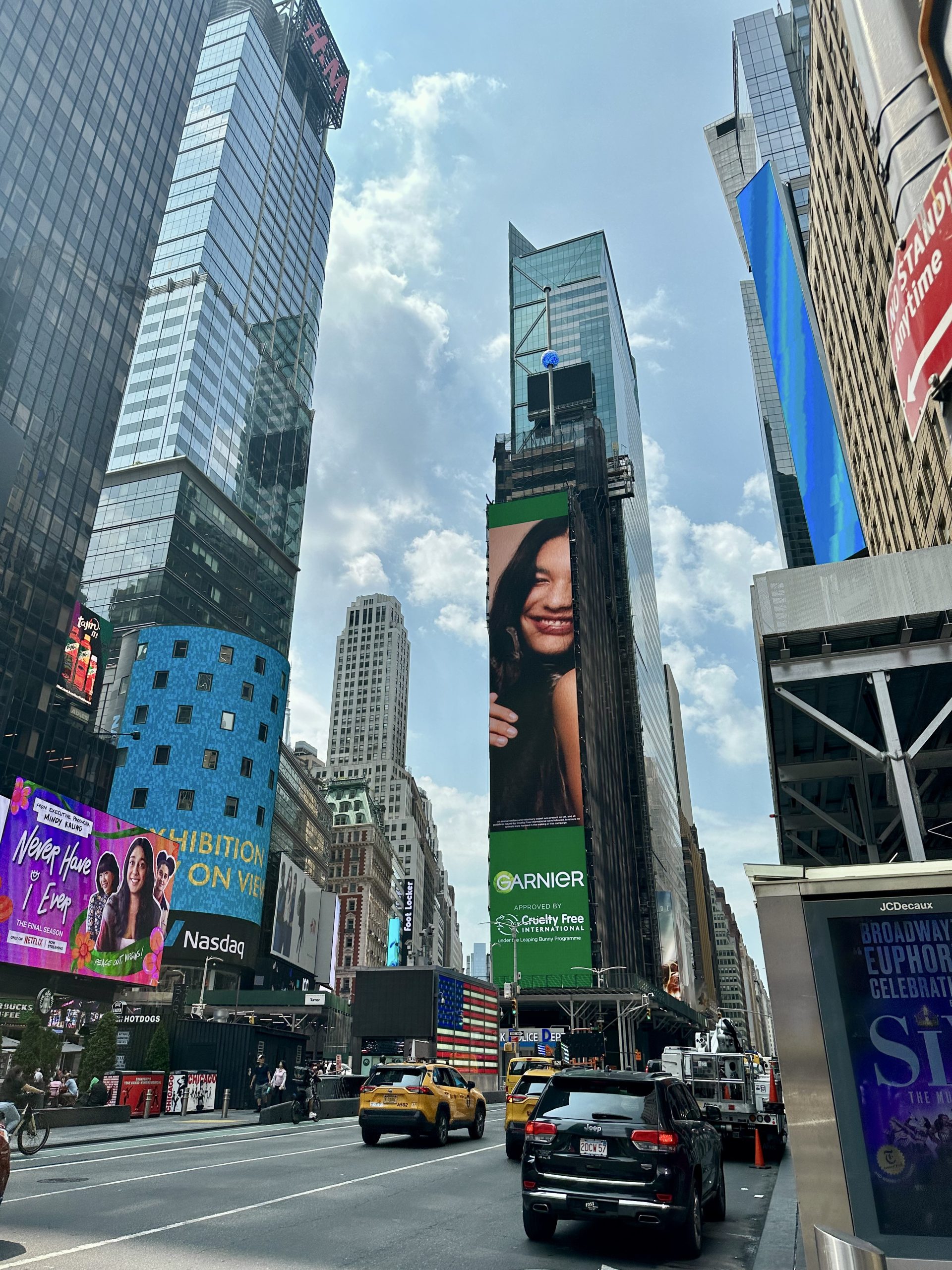 Bustling crowd in Times Square with brightly lit billboards and advertisements.