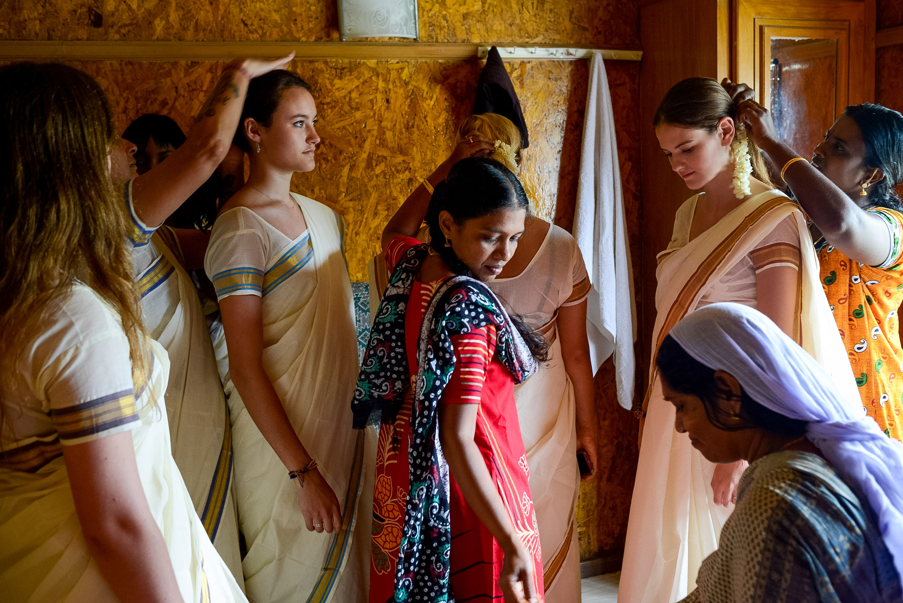 Local women help students wrap traditional saris indoors