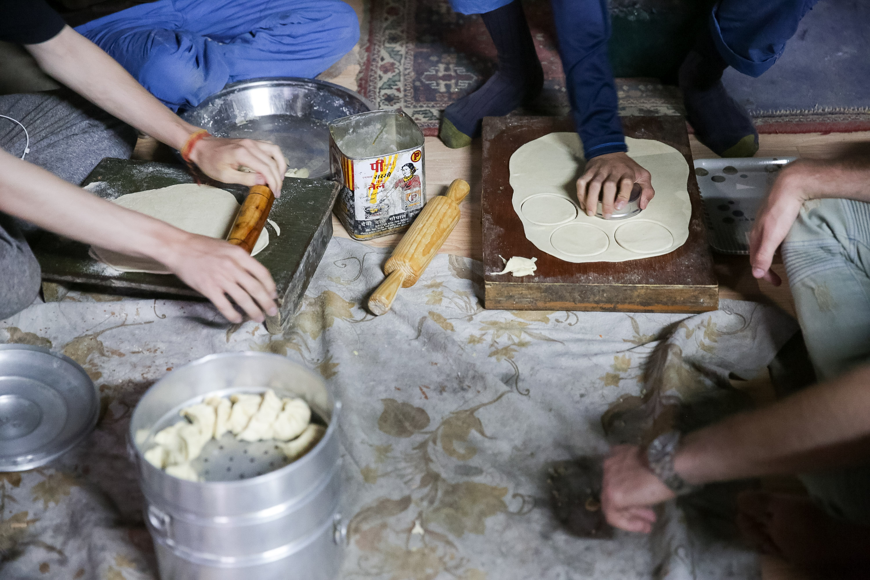 On a school trip, students roll and shape dough on wooden boards while preparing traditional bread