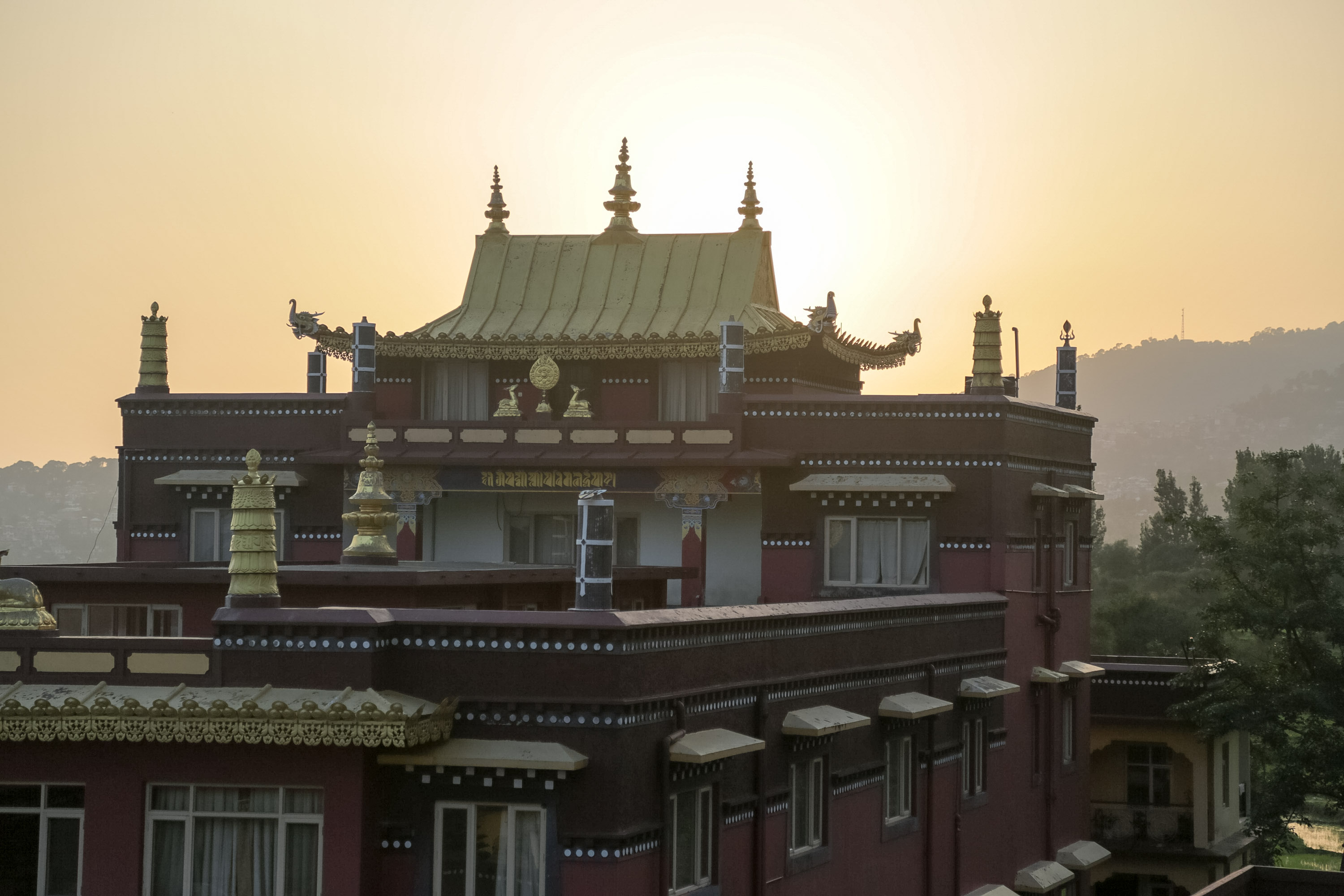 A school trip stops at a temple with an ornate golden roof glowing at sunset