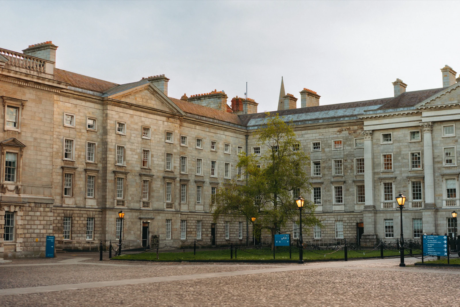 The long granite facade of a Trinity College square in Dublin, with rows of tall sash windows
