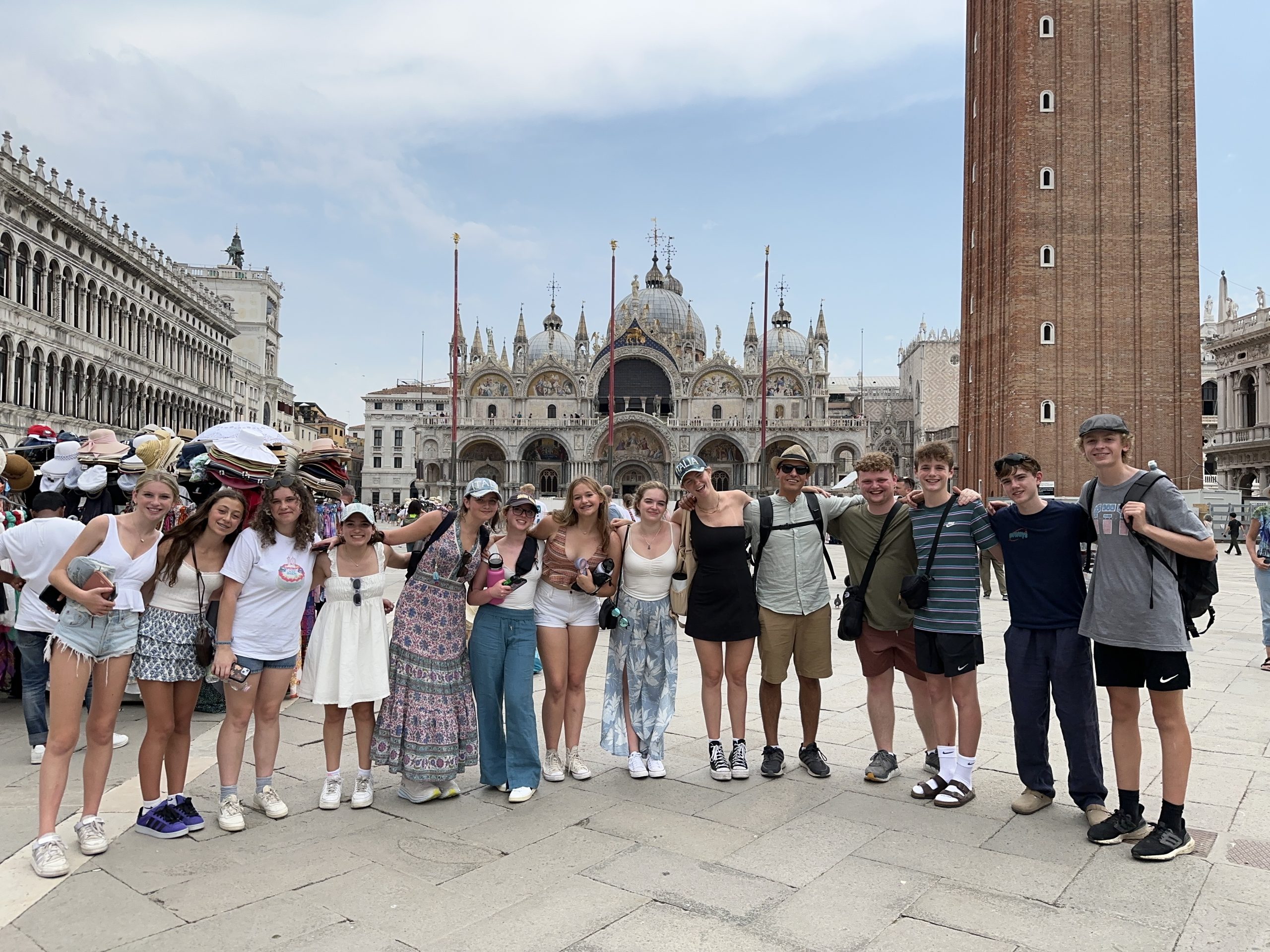 Student travelers pose together in St. Mark's Square with the basilica and bell tower behind them