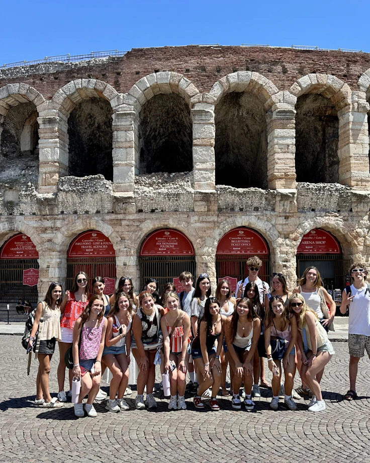 A Rustic Pathways group stands on the cobbled square in front of the Roman Arena in Verona, Italy