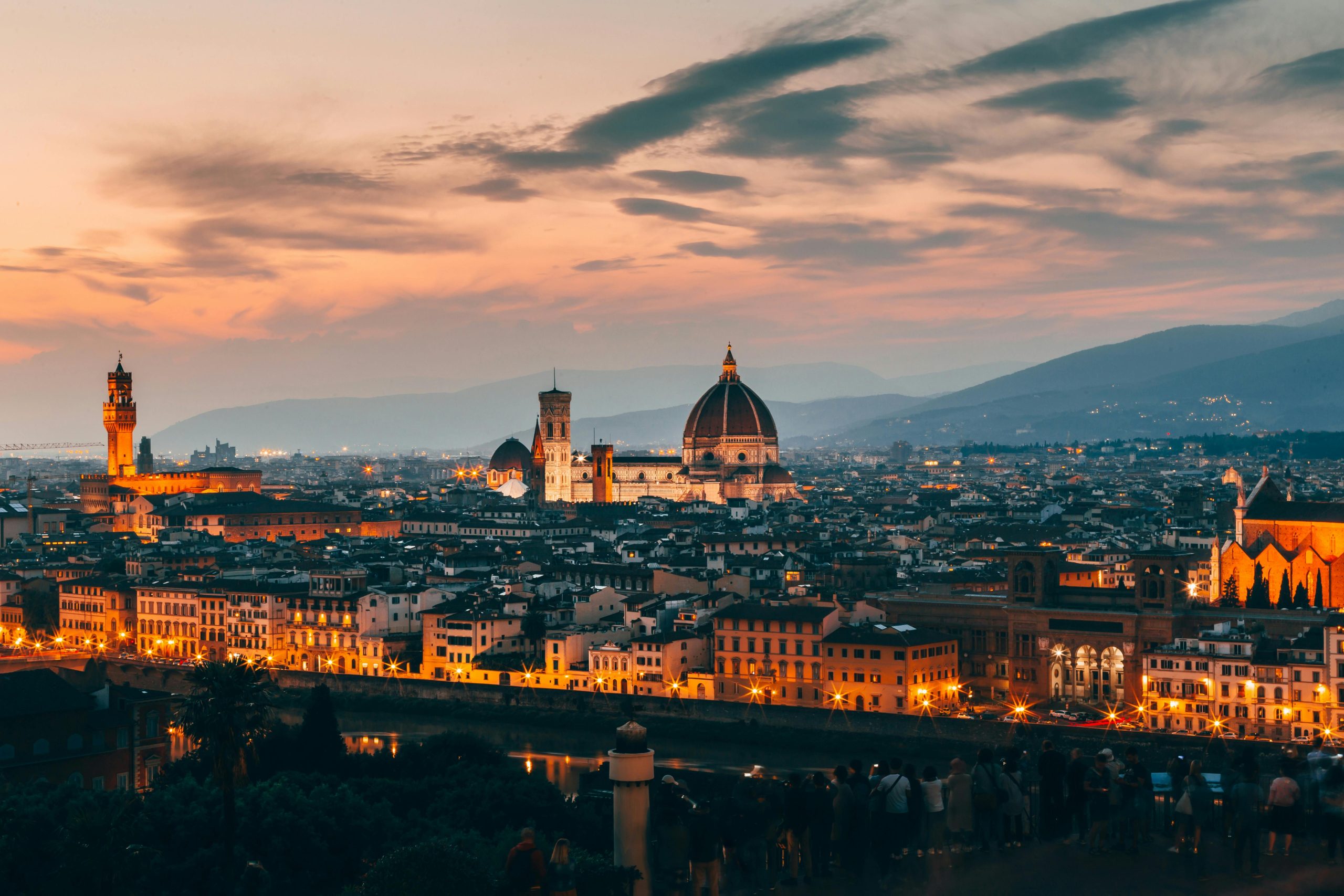 Florence skyline glows at dusk with the cathedral dome rising above city rooftops