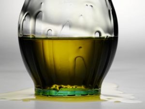 a glass with a olive oil liquid in it