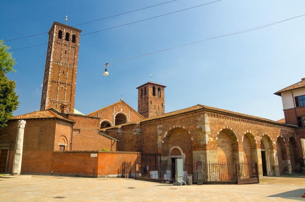 The Basilica of Sant'Ambrogio in Milan with its brick towers and arched entrance.