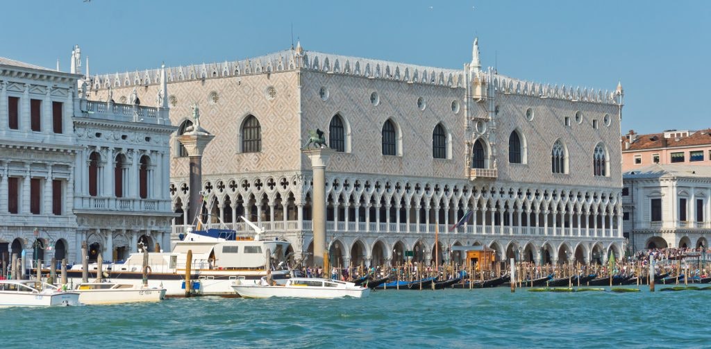 The Doge’s Palace in Venice, overlooking the Grand Canal with boats docked nearby.