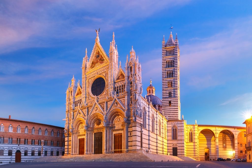 The Siena Cathedral in Italy, glowing at sunset with intricate Gothic details.