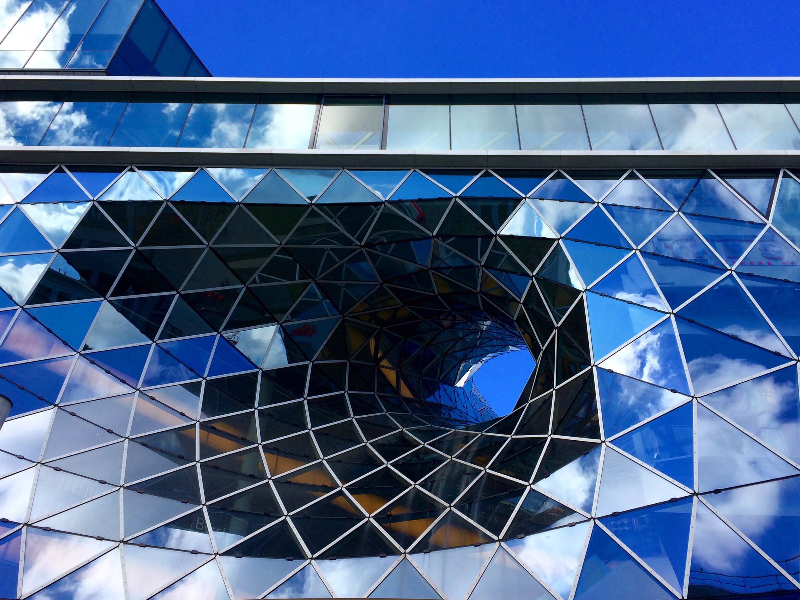 Modern glass building with a unique architectural design.