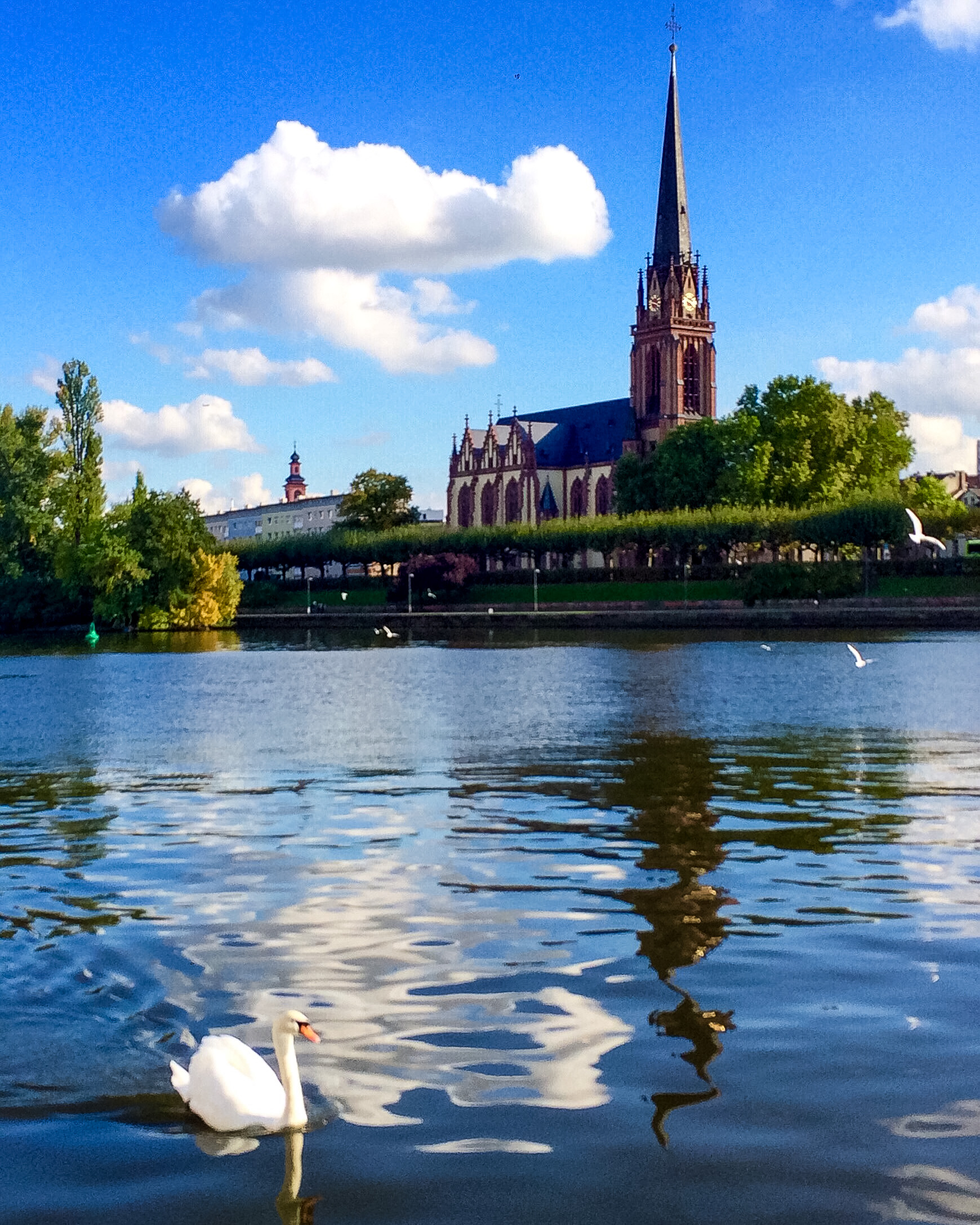A church by the river with a blue sky and trees in the background. fun facts about germany