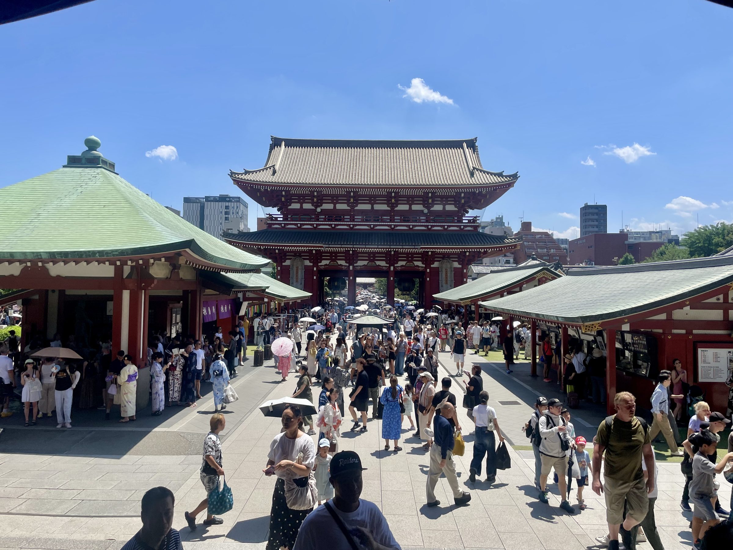 The Hōzōmon gate rises above the courtyard at Sensō-ji as visitors cross in summer sun