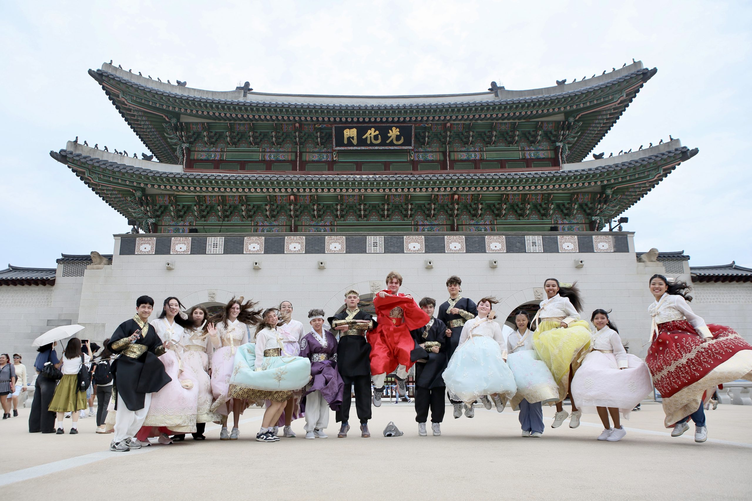 A group of Rustic Pathways student travelers wearing Korean Hanbok at Gyeongbokgung palace in Seoul.