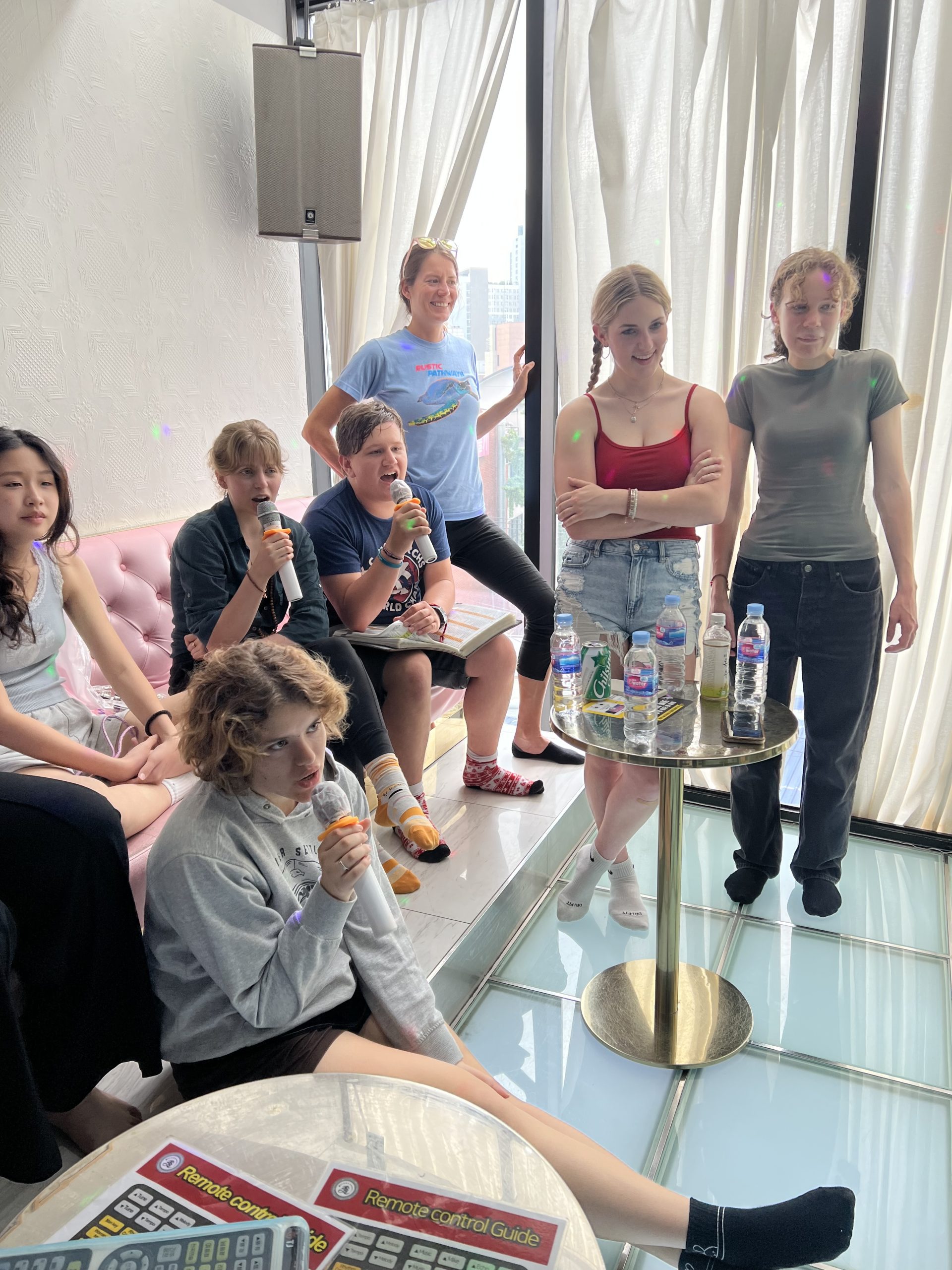 A group of teens singing karaoke in a Korean "noraebang" on a student travel program in Seoul.