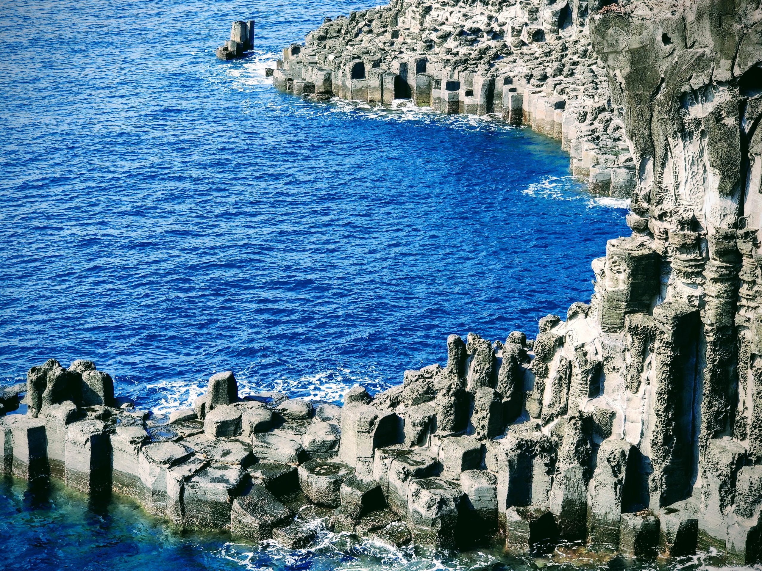 Basalt cliffs of the coast of Jeju Island, South Korea, featuring volcanic terrain and natural beauty.