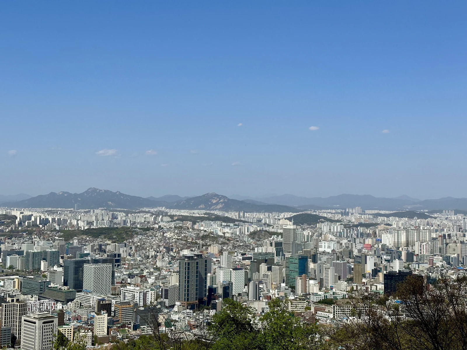 High-rise districts of Seoul spread toward the mountains, seen from Namsan