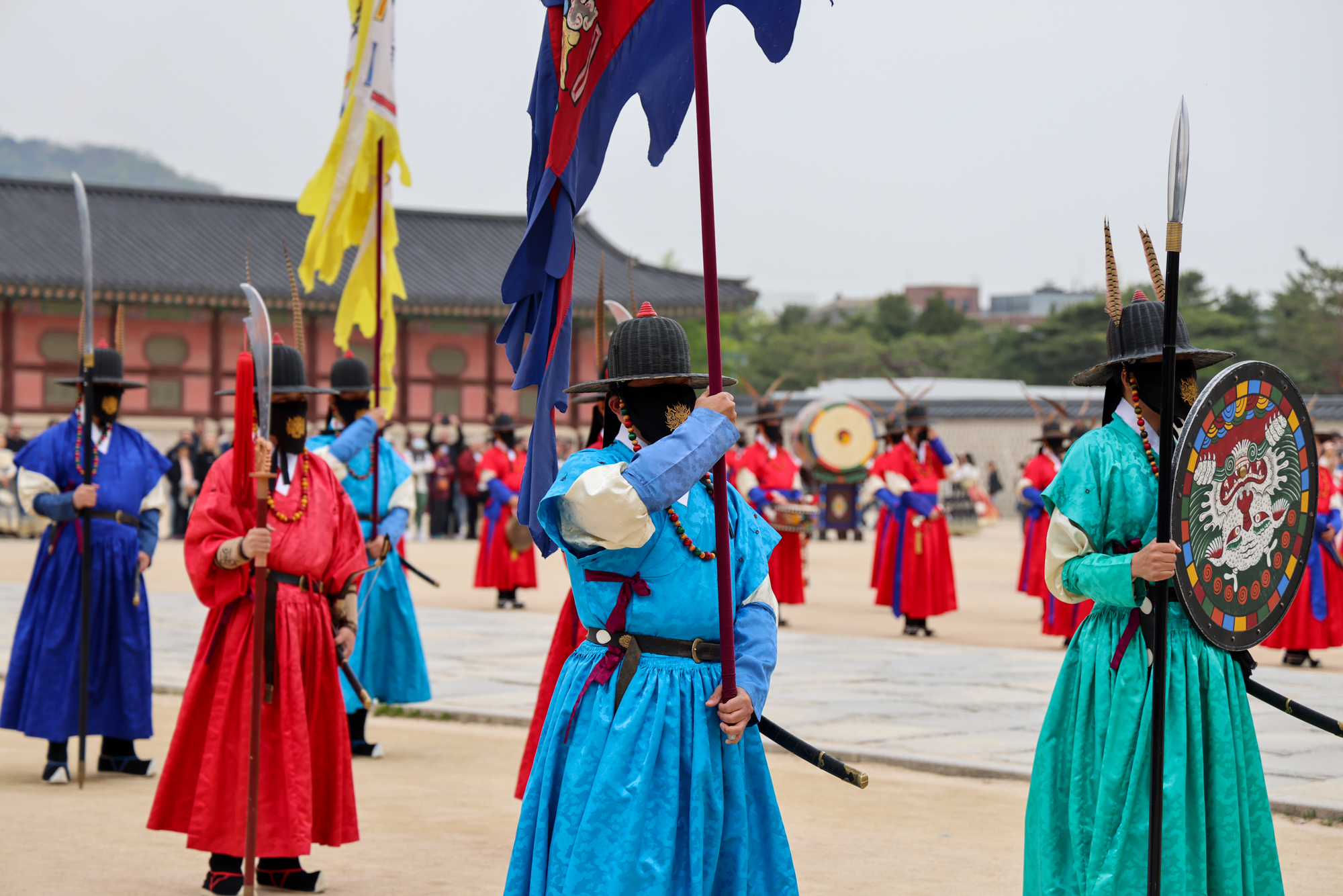 Royal guards in blue and red robes stand in formation at Gyeongbokgung Palace