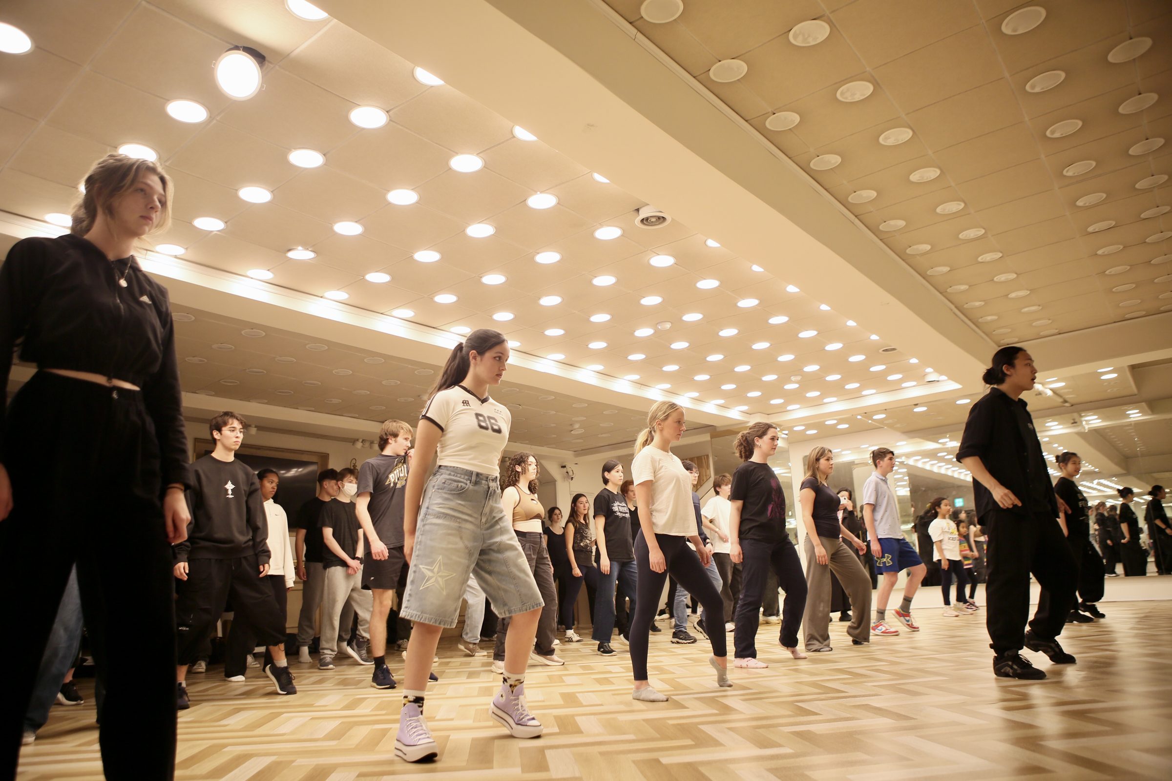 A studio full of students mid-routine in a K-pop dance class